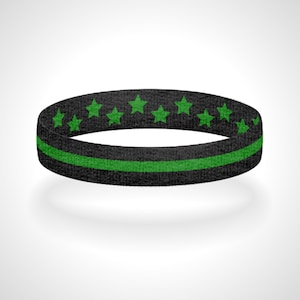 Pode incluir: Pulseira de borracha preta e verde com uma fina faixa verde e estrelas verdes ao redor da borda.