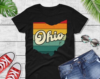 Könnte beinhalten: Schwarzes T-Shirt mit einem Vintage-Grafikdruck des Bundesstaates Ohio. Die Grafik zeigt ein Regenbogen-Farbschema und das Wort "Ohio" in einer Retro-Schriftart.