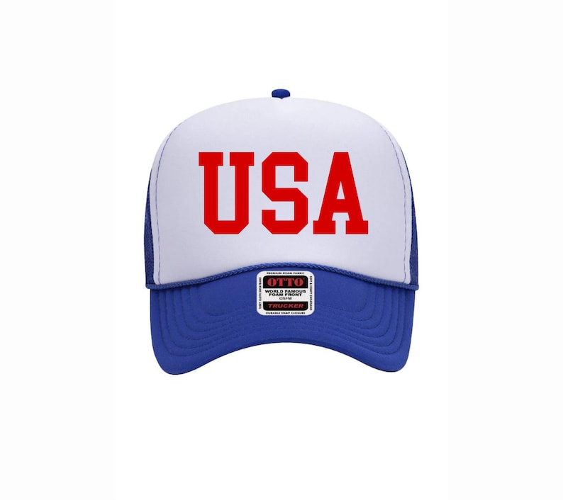 May include: A blue and white trucker hat with the word "USA" in red block letters across the front. The hat has a blue brim and a white foam front. The hat also has a small patch that says "OTTO".