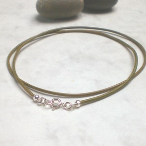 May include: A green leather cord necklace with silver clasp and beads.
