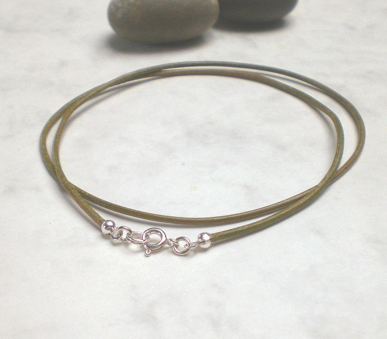 May include: A green leather cord necklace with silver clasp and beads.
