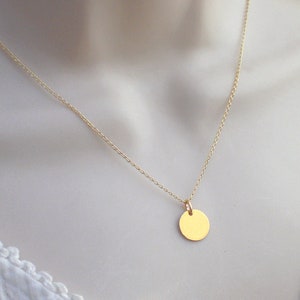 May include: A gold chain necklace with a small, round pendant.