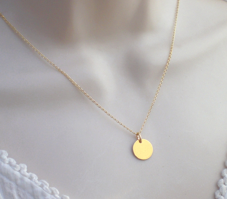 May include: A gold chain necklace with a small, round pendant.