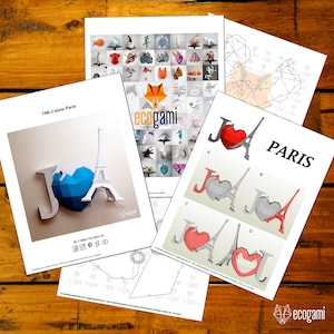 May include: A papercraft model of the Eiffel Tower and a heart with the letters "J'aime Paris" printed on it. The model is made of white paper and is ready to be assembled. The model is part of a collection of papercraft models from ecogami.