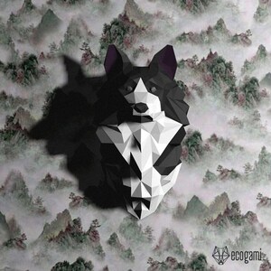 Peut inclure: Un mod&egrave;le en papier origami de la t&ecirc;te d'un chien, en noir et blanc. Le chien a un visage blanc et des oreilles, un corps et une queue noirs. L'arri&egrave;re-plan est une image floue d'un paysage montagneux.