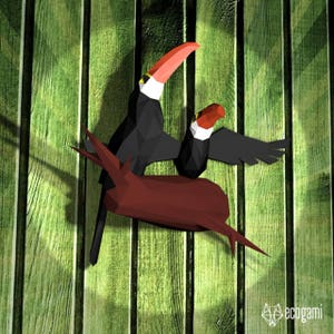 May include: Two origami toucans perched on a brown branch, with a green wooden background. The toucans are black with yellow and red accents.