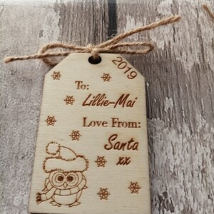 May include: A wooden Christmas ornament with a cute owl design. The ornament is personalized with the text "To: Lillie-Mai Love From: Santa xx" and the year "2019".