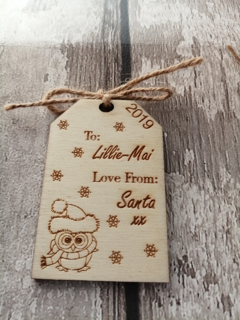 May include: A wooden Christmas ornament with a cute owl design. The ornament is personalized with the text "To: Lillie-Mai Love From: Santa xx" and the year "2019".