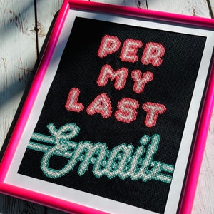 May include: A framed cross-stitch with a black background and pink frame. The cross-stitch reads "Per My Last Email" in a pixelated font. The words "Per My" are in pink and the word "Last" is in red. The words "Email" are in green.