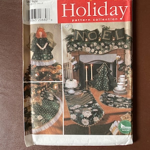 Può includere: Collezione di modelli Simplicity Holiday. L'immagine mostra un modello per decorazioni natalizie, tra cui un angelo, una gonna per albero, un runner da tavolo e decorazioni per il camino. Il modello presenta un motivo floreale verde e bianco con la parola "NOEL".