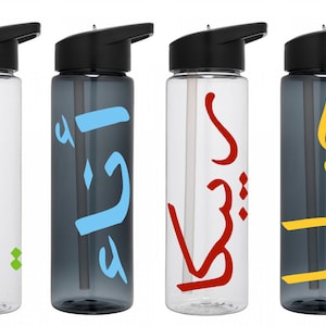 May include: Four clear plastic water bottles with black lids and straws. Each bottle has a different Arabic word written on it in a different color: green, blue, red, and yellow.