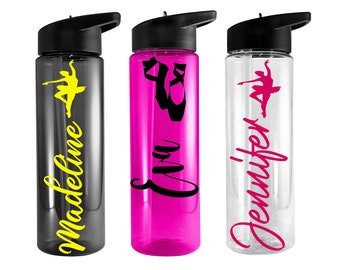 May include: Three clear plastic water bottles with black lids and flip tops. The bottles are personalized with names and a dancer silhouette. The names are "Madeline" in yellow, "Eva" in black, and "Jennifer" in pink.