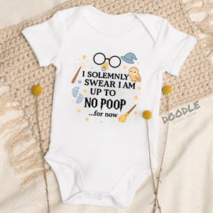 May include: White baby onesie with a whimsical design featuring glasses, a hat, an owl, and a broom. The text reads "I SOLEMNLY SWEAR I AM UP TO NO POOP...for now." The Doodle Studio Store logo is visible.