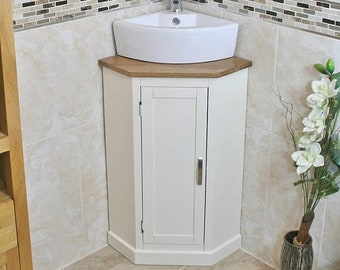 May include: White corner bathroom vanity with a white ceramic sink and a wood countertop. The vanity has a single door and a small cabinet above the sink with a mirror.