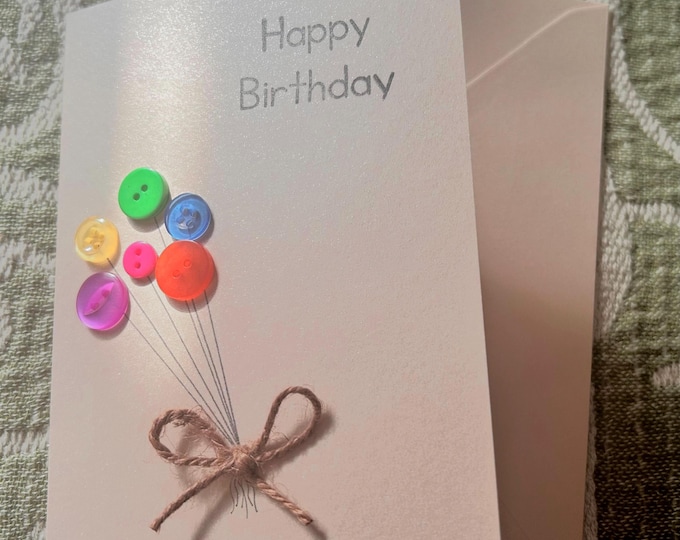 Handmade Birthday Card: pearlescent peach coloured card with colourful balloon buttons