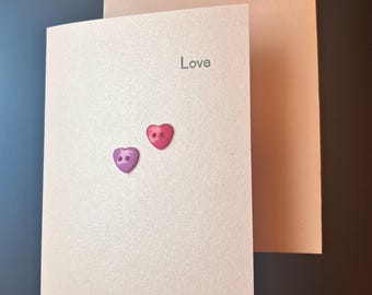 Handmade love card. pearlescent pink coloured card with colourful heart buttons