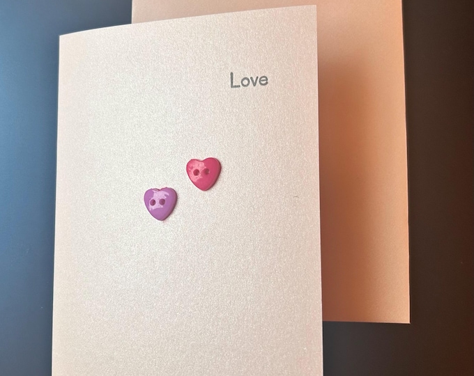 Handmade love card. pearlescent pink coloured card with colourful heart buttons