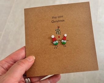 Under  the mistletoe. Festive pea card