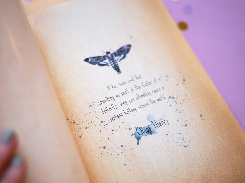 May include: Open book page with a moth illustration and text. The text reads "It has been said that something as small as the flutter of a butterfly's wing can ultimately cause a typhoon halfway around the world. Chaos Theory."