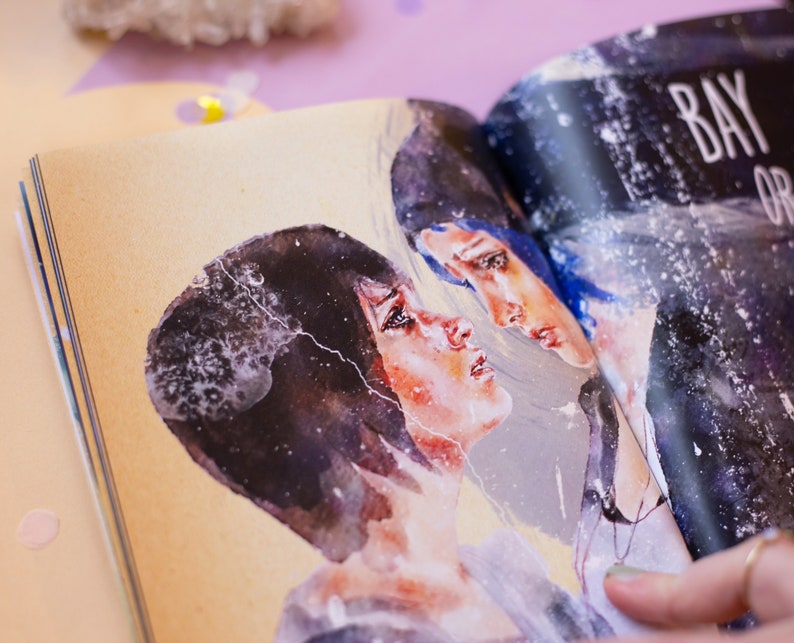 May include: Open book with watercolor illustrations of two figures with dark hair and blue hair. The figures are facing each other with a soft, emotional expression. The page has the text "BAY OR" in white.