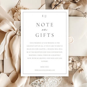 Puede incluir: Un conjunto de invitaciones de boda con una tarjeta blanca con el texto "NOTE or GIFTS" y un sobre color crema. La invitación está rodeada de cintas, tela y flores secas de color crema. El texto incluye las iniciales y el sitio web de la pareja.