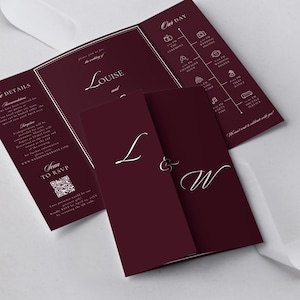 Könnte beinhalten: Burgunderfarbene Hochzeitseinladungssuite mit weißem Schrifttext. Die Einladung ist dreifach gefaltet und enthält Details, einen Zeitplan und RSVP-Informationen. Auf der Vorderseite stehen die Namen "Louise und W". Ein weißes Band ist im Hintergrund.