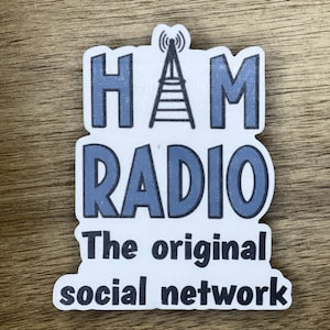 May include: A white sticker with blue text that reads "HAM RADIO The original social network". A black and white illustration of a radio antenna is above the text.