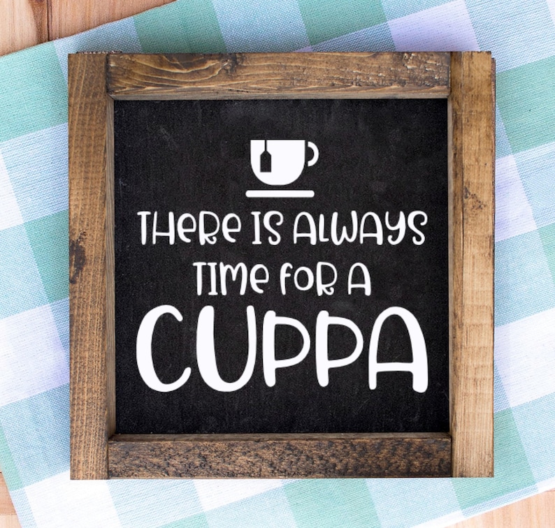 May include: Square wooden sign with a black background and white text that reads "THERE IS ALWAYS TIME FOR A CUPPA". The sign has a white graphic of a teacup and a tea bag. The frame is made of brown wood.