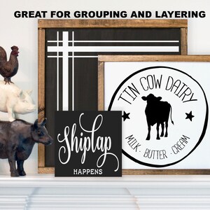 Puede incluir: Decoraci&oacute;n de estilo r&uacute;stico con un gallo marr&oacute;n sobre un cerdo blanco, que est&aacute; sobre una figura de vaca marr&oacute;n oscuro. Hay tres letreros de madera con texto y dise&ntilde;os blancos, incluyendo "ShipLap HAPPENS" y "TIN COW DAIRY".