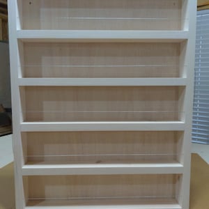 May include: White wooden spice rack with five shelves and wire dividers. The rack is empty.