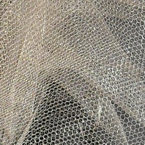 Op de afbeelding: Close-up van een doorschijnend, wit, gaasweefsel met een fijn, geweven patroon. De stof heeft een licht getextureerd oppervlak en een delicate, luchtige uitstraling.