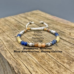 May include: A beaded bracelet with a white cord and adjustable closure. The bracelet features a variety of colorful beads, including blue, yellow, white, and orange. Text on the image reads: Sunstone, Howlite, Blue Aventurine, Honey Calcite.