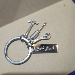 May include: Silver keyring with a hammer, screwdriver, wrench, and a tag that says "Best Dad".