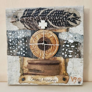 May include: Mixed media artwork on canvas. It features a large feather with black and white spots, a tan circular object with a dark centre, and the text "Sacred Musings". The artwork has a rustic, textured appearance with neutral tones.