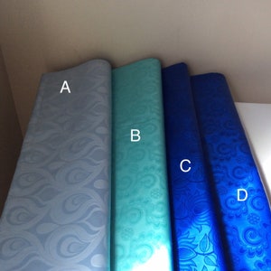 May include: Four fabric swatches in different shades of blue. The swatches are arranged from left to right in the following order: light blue, turquoise, dark blue, and royal blue. Each swatch has a different pattern.