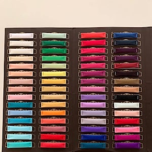 May include: A colour chart with 66 fabric swatches, each labelled with a number. The swatches are arranged in rows and columns, and the colours range from white to black, with many shades in between.