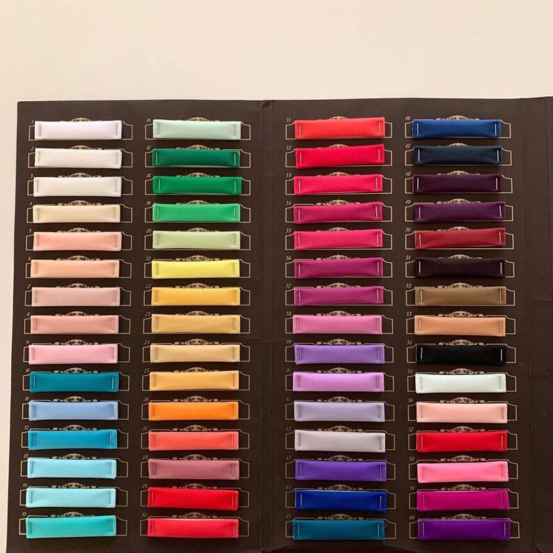May include: A colour chart with 66 fabric swatches, each labelled with a number. The swatches are arranged in rows and columns, and the colours range from white to black, with many shades in between.