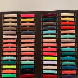 May include: A colour chart with 20 rows of fabric swatches. Each row has 3 fabric swatches. The swatches are numbered 61 to 80 on the left side and 91 to 110 on the right side. The swatches are in a variety of colours, including red, orange, yellow, green, blue, purple, pink, brown, grey, and black.
