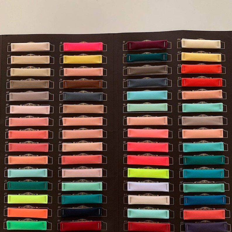 May include: A colour chart with 20 rows of fabric swatches. Each row has 3 fabric swatches. The swatches are numbered 61 to 80 on the left side and 91 to 110 on the right side. The swatches are in a variety of colours, including red, orange, yellow, green, blue, purple, pink, brown, grey, and black.