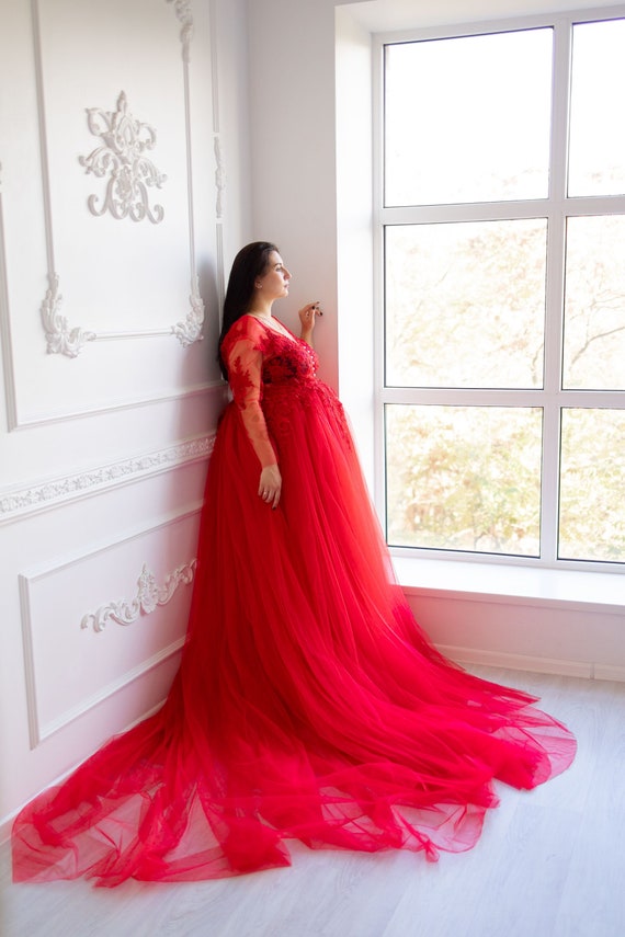 Look de hermana de la novia con vestido rojo con plumas