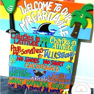 May include: A multi-tiered wooden sign with a rope hanger, painted in bright colors with text reading Welcome to our Margaritaville, Changes in Latitude, Changes in Attitude, Pour me something tall and strong, No shoes no shirt encouraged, and more.