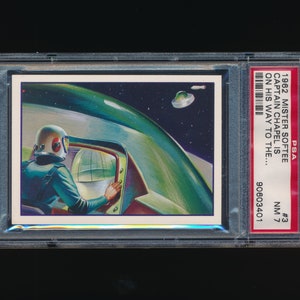 May include: A vintage trading card featuring a cartoon illustration of a spaceman in a green spaceship. The card is from the 1962 Mister Softee series and features the text "Captain Chapel is on his way to the..."