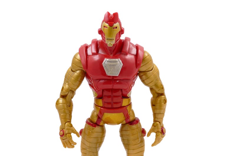 May include: A red and gold Iron Man action figure. The figure has a red torso and head with gold arms, legs, and accents. The figure has a silver chest plate and is standing upright.
