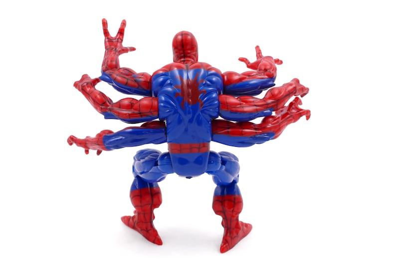 May include: A Spider-Man action figure with multiple arms. The figure is primarily blue and red, with a red spider emblem on the back. The arms are outstretched, and the figure is posed against a white background.