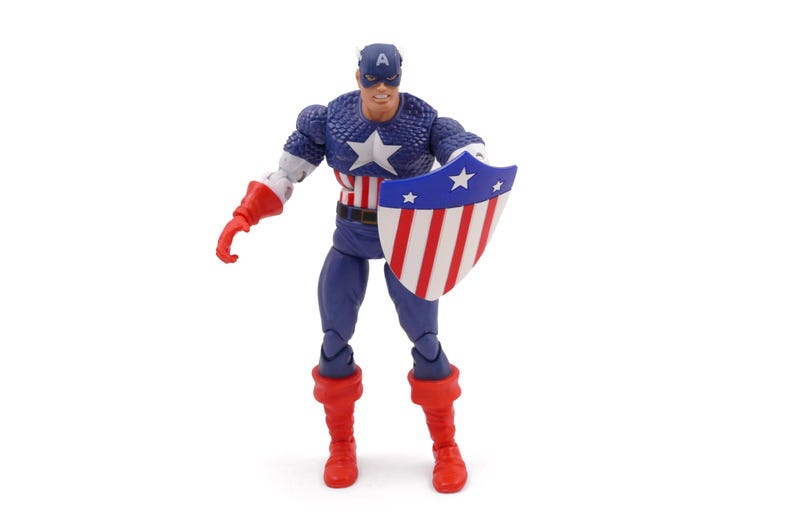 K&ouml;nnte beinhalten: Eine Captain America-Actionfigur vor wei&szlig;em Hintergrund. Die Figur tr&auml;gt ein blau-wei&szlig;es Kost&uuml;m mit einem Stern auf der Brust und einem passenden Helm. Sie h&auml;lt einen Schild mit roten und wei&szlig;en Streifen und blauen Sternen.