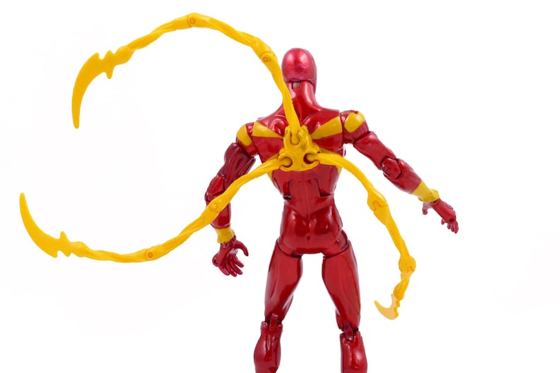 May include: A red and yellow action figure with articulated limbs and a pair of yellow, web-like appendages attached to the back.