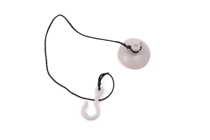 May include: A light gray suction cup with a black cord and a matching hook. The suction cup is round and has a small hole in the center. The hook is curved and has a small loop at the top. The cord connects the two pieces.