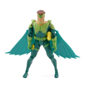 May include: A green and teal action figure of a superhero with a brown hairstyle and teal wings. The figure is wearing a green and teal suit with a yellow belt and accessories. The figure is posed with legs spread and arms at its sides.