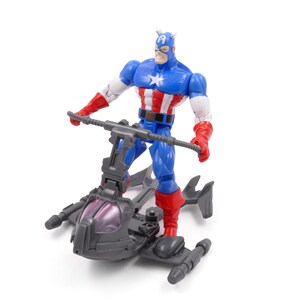 Pode incluir: Uma figura de a&ccedil;&atilde;o do Capit&atilde;o Am&eacute;rica em um traje azul, vermelho e branco, em p&eacute; em um ve&iacute;culo cinza com uma capota roxa. A figura tem uma estrela no peito e um capacete com asas.