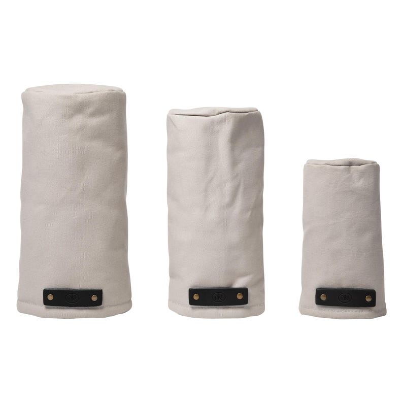 May include: Three cylindrical golf club head covers in varying heights, crafted from off-white fabric. Each cover features a rectangular black leather tab at the base, secured with two metallic rivets, providing a contrast to the light material.